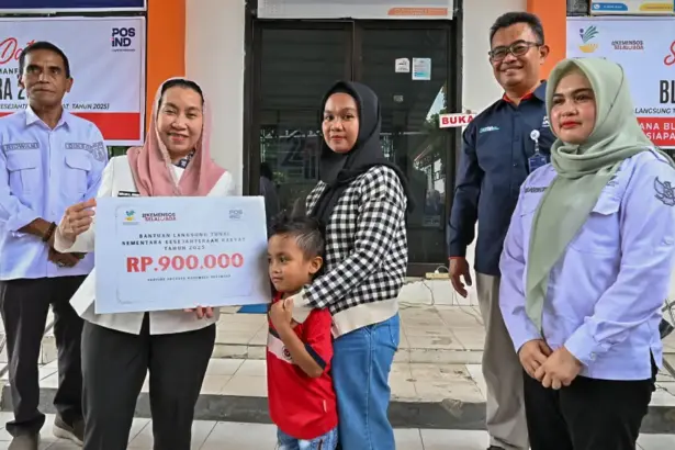 Waali Imleda disaksikan GM PT Pos Indonesia Palu Supriantoro menyerahkan secara simbolis BLTS Kesra 2025 di halaman Kantor Pos Palu, Rabu (26/11/2025). (©bmzIMAGES/Basri Marzuki)