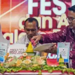 Kepala OJK Sulteng Bonny Hadi Putra (kanan) bersama Wawali Palu Imelda Liliana Muhidin (kiri) memotong tumpeng menandai peringatan HUT ke-14 OJK sekaligus puncak Festival UMKM dan Akses Permodalan di LapanganVatulemo, Palu, Sabtu (22/11/2025). (©Prokopim Setda Kota Palu/Jufri)