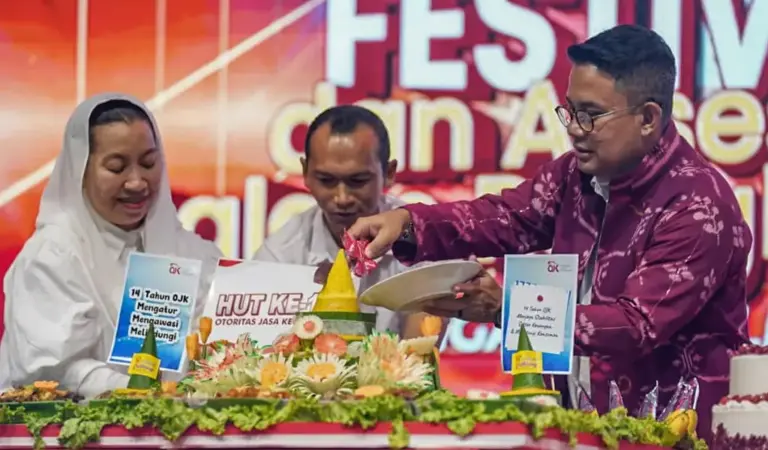 Kepala OJK Sulteng Bonny Hadi Putra (kanan) bersama Wawali Palu Imelda Liliana Muhidin (kiri) memotong tumpeng menandai peringatan HUT ke-14 OJK sekaligus puncak Festival UMKM dan Akses Permodalan di LapanganVatulemo, Palu, Sabtu (22/11/2025). (©Prokopim Setda Kota Palu/Jufri)