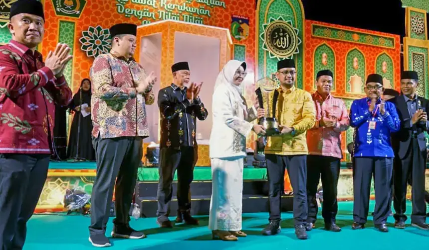 Asisten Administrasi Umum Setda Kota Palu, Eka Komalasari menyerahkan piala kepada kontingan Palu Selatan yang meraih juara umu pada MTQ ke-28 di Tipo, Ulujadi, Rabu (4/11/2025). (©Prokopim Setda Kota Palu/Yuspi)