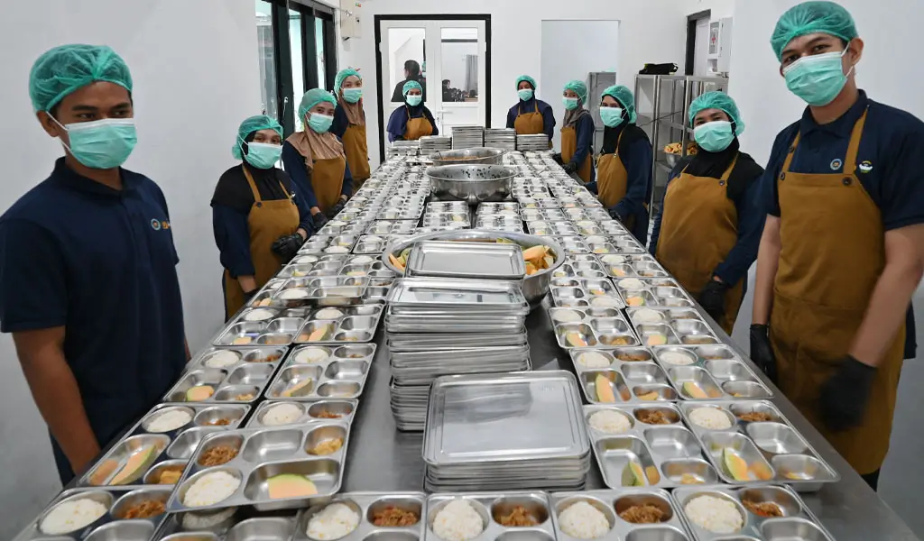 Para petugas berpose di ruang produksi SPPG Polda Sulteng, Selasa (11/11/2025). (©bmzIMAGES/Basri Marzuki)