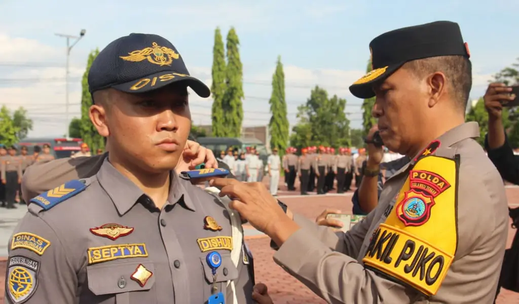 Wakapolda Sulteng, Brigjen Pol Helmi Kwarta Kusuma Putra Rauf memasangkan pita menandai dimulainya Operasi Zebra Tinombala 2025 di Mapolda Sulteng, Senin (17/11/2025). (©Humas Polda Sulteng)