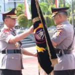 Pejabat Kapolda lama Irjen Pol Agus Nugroho (kanan) menyerahkan pataka kepada pejabat Kapolda baru, Irjen Pol Endi Sutendi di Mapodla Sulteng, Senin (3/11/2025). (©Humas Polda Sulteng)
