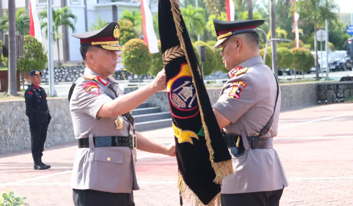 Pejabat Kapolda lama Irjen Pol Agus Nugroho (kanan) menyerahkan pataka kepada pejabat Kapolda baru, Irjen Pol Endi Sutendi di Mapodla Sulteng, Senin (3/11/2025). (©Humas Polda Sulteng)