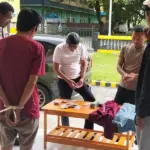 Petugas menata barang bukti uang hasil pencurian di depan pelaku di Mapolsek Tawaeli, Palu, Senin (17/11/2025). (©HUmas Polresta Palu)