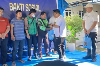 Kakanwil Ditjenpas Sulteng, Bagus Kurniawan menyerahkan paket sembako pada Baksos bersama Kanwil Ditjenim Sulteng di palu, Jumat (14/11/2025). (©Humas Ditjenpas Sulteng)