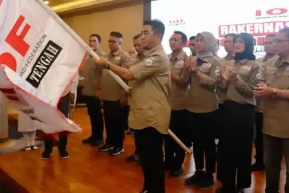 Ketua IOF Pengda Sulteng, Kombes Pol Pribadi Sembiring mengangkat bendera IOF pada pelantikan di Palu, Jumat (14/11/2025). (⌐IOF Sutleng)