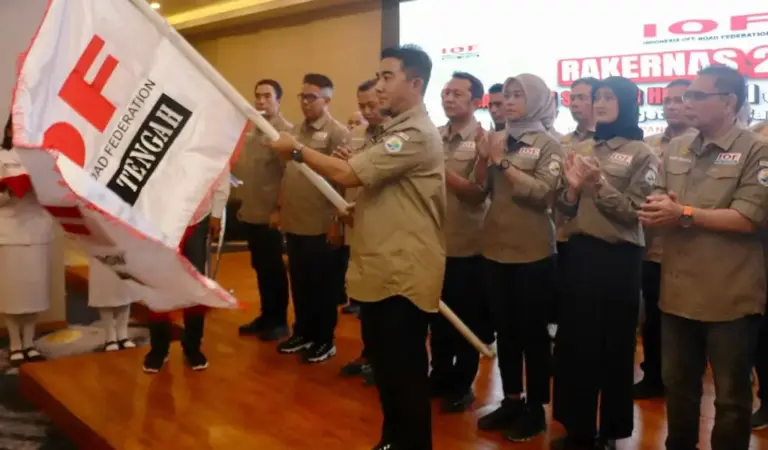 Ketua IOF Pengda Sulteng, Kombes Pol Pribadi Sembiring mengangkat bendera IOF pada pelantikan di Palu, Jumat (14/11/2025). (⌐IOF Sutleng)