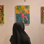 Pengunjung memperhatikan lukisan yang dipajang pad apameran lukisan Ruang Rupa Rasa di Rumah Tiara Coffee, Palu, Minggu (9/11/2025) malam. (©bmzIMAGES/Basri Marzuki)