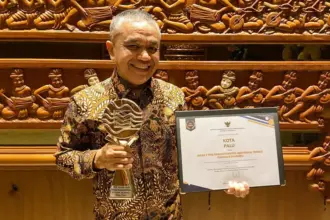 Wali Kota Palu, Hadianto Rasyid menunjukkan tropi dan sertifikat usai menerima penghargaan TPID terbaik di Jakarta, Jumat (28/11/2025). (©Prokopim Setda Kota Palu)