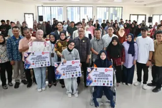 Sejumlah wirausaha muda menunjukkan atribut bantuan modal usaha usai menerima bantuan permodalan dalam program inkubasi bisnis di Media Center, Untad, Jumat (14/11/2025). (©nmzIMAGES/Basri Marzuki)