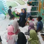 Nur Indah Fitriani Sofyan menggunakan papan tulis portabel dari MR.D.I.Y. untuk mengajar murid-muridnya. (©MR DIY)