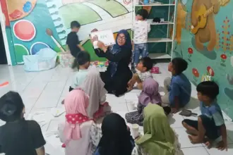 Nur Indah Fitriani Sofyan menggunakan papan tulis portabel dari MR.D.I.Y. untuk mengajar murid-muridnya. (©MR DIY)