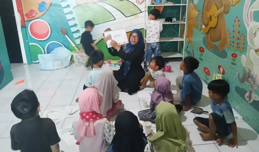 Nur Indah Fitriani Sofyan menggunakan papan tulis portabel dari MR.D.I.Y. untuk mengajar murid-muridnya. (©MR DIY)