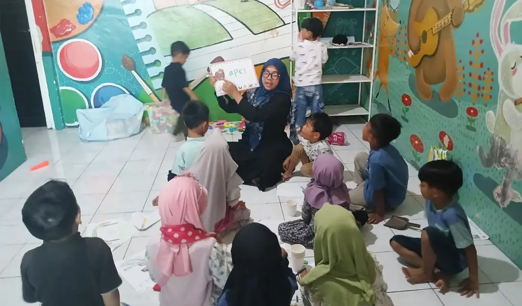 Nur Indah Fitriani Sofyan menggunakan papan tulis portabel dari MR.D.I.Y. untuk mengajar murid-muridnya. (©MR DIY)