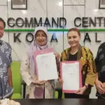 Kepala Diskominfosantik Kota Palu, Ridwan karim (kiri) pada penyerahan website kepada DPPKB dan Dinas Perdagin Kota Palu di Palu, Kamis (4/12/2025). (©Diskominfosantik Palu)