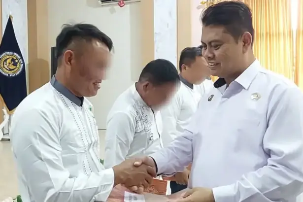 Kakanwil Ditjernpas Sulteng, Bagus Kurniawan menyerahkan remisi natal kepada salah seorang warga binaan pemsayarakatan di palu, Kamis (25/12/2025). (©Humas Ditjenpas Sulteng)