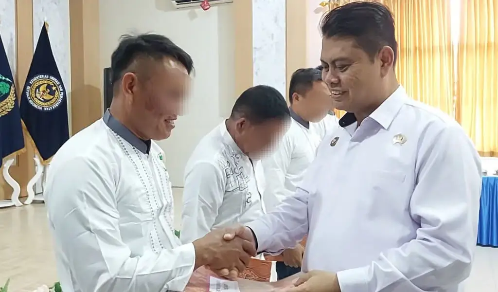 Kakanwil Ditjernpas Sulteng, Bagus Kurniawan menyerahkan remisi natal kepada salah seorang warga binaan pemsayarakatan di palu, Kamis (25/12/2025). (©Humas Ditjenpas Sulteng)