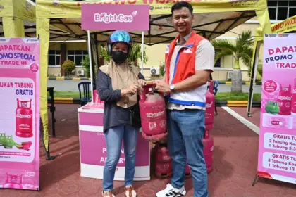 Petugas menyerahkan tabung Bright Gas kepada warga yang melakukan penukaran tabung di Pasar Murah, Mapolresta Palu, Jumat (5/12/2025). (©bmzIMAGES/Basri Marzuki)