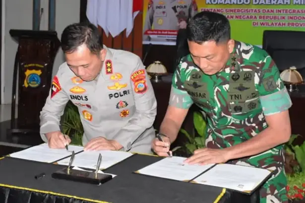 Kapolda Sulteng Irjen Pol Endi Sutendi (kiri) dan Pangdam XXIII/Palaka Wira Mayjen TNI Jonathan Binsar Parluhutan Sianipar meneken naskah PKS di Mapodla Sulteng, Jumat (19/12/2025). (©Pendam 23/Pw)