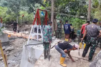 Sejumlah personel TNI bersama warga bergotong royonh merenovasi jembatan gantung Likunggavali di Parigi Moutong. (©Penrem 132/Tdl)