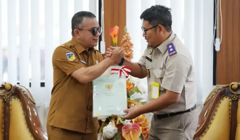 Kepala Kantor BPN Kota Palu, Susetyo Nugroho menyerahkan sertifikat aset milik Pemkot Palu kepada Wali Kota Palu, Hadianto Rasyid di ruang kerja Wali Kota Palu, Selasa (30/12/2025). (©Prokopim Setda Kota Palu/Jufri)