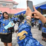 Seorang Pegawai Pemerintah dengan Perjanjian Kerja (PPPK) Paruh Waktu berfoto usai mengikuti seremonial pelantikan dan penyerahan SK di Lapangan Pogombo, Kantor Gubernur Sulteng di Palu, Sulawesi Tengah, Rabu (31/12/2025). (©bmzIMAGES/Basri Marzuki)