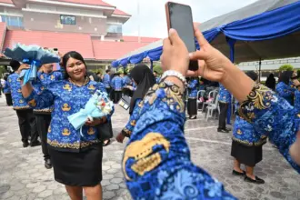 Seorang Pegawai Pemerintah dengan Perjanjian Kerja (PPPK) Paruh Waktu berfoto usai mengikuti seremonial pelantikan dan penyerahan SK di Lapangan Pogombo, Kantor Gubernur Sulteng di Palu, Sulawesi Tengah, Rabu (31/12/2025). (©bmzIMAGES/Basri Marzuki)