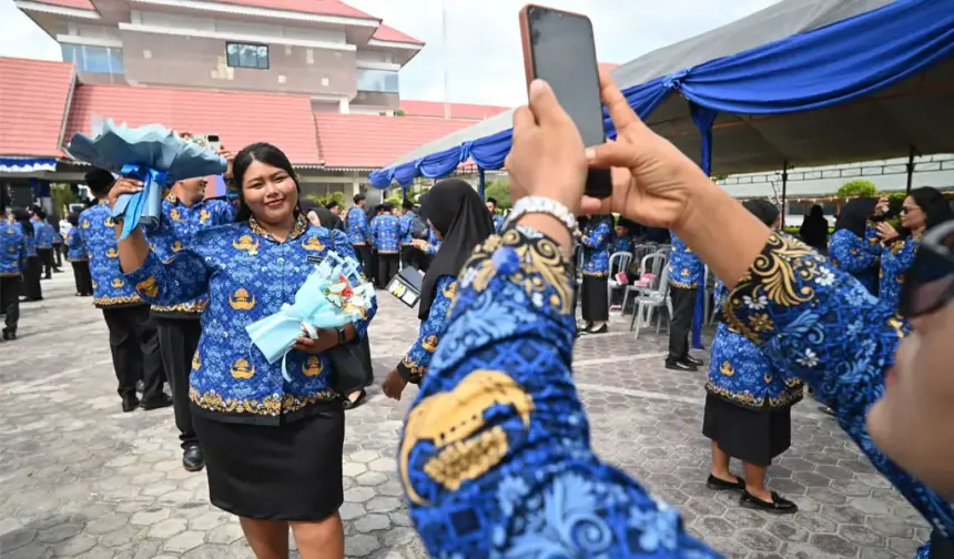 Seorang Pegawai Pemerintah dengan Perjanjian Kerja (PPPK) Paruh Waktu berfoto usai mengikuti seremonial pelantikan dan penyerahan SK di Lapangan Pogombo, Kantor Gubernur Sulteng di Palu, Sulawesi Tengah, Rabu (31/12/2025). (©bmzIMAGES/Basri Marzuki)