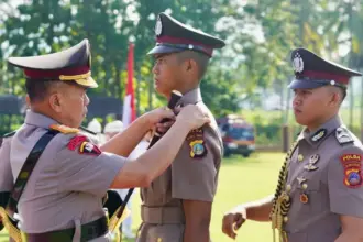 Kapolda Sulteng Irjen Pol Endi Sutendi (kiri) menyematkan tanda pangkat kepada peserta Diktuba yang dinyatakan lulus di SPN Panimba, Rabu 924/12/2025). (©Humas Polda Sulteng)