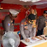 Kapolresta Palu Kombes Pol Deny Abrahams mengisi buku tamu saat melakukan inspeksi ke salah satu Pos Pengamanan Natura di Palu, Rabu (24/12/2025). (©Humas Polresta Palu)