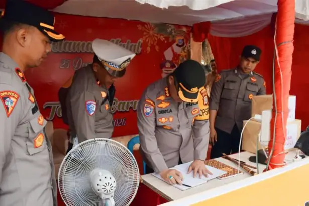 Kapolresta Palu Kombes Pol Deny Abrahams mengisi buku tamu saat melakukan inspeksi ke salah satu Pos Pengamanan Natura di Palu, Rabu (24/12/2025). (©Humas Polresta Palu)