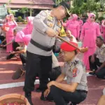 Kapolresta Palu Kombes Pol Deny Abrahams menyiramkan air kembang kepada personel yang naik pangkat di Mapolresta Palu, Rabu (31/12/2025). (©Humas Polresta Palu)