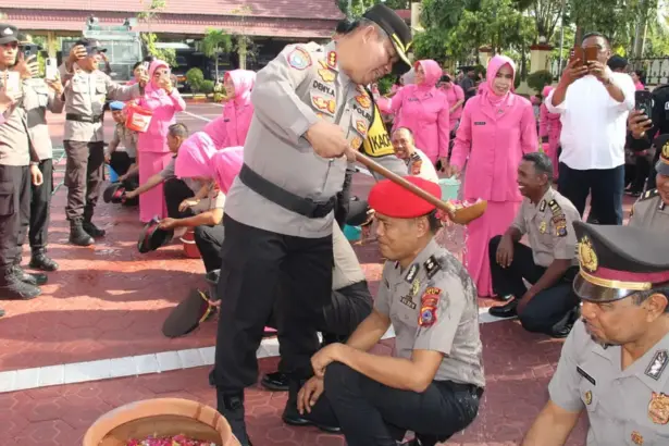 Kapolresta Palu Kombes Pol Deny Abrahams menyiramkan air kembang kepada personel yang naik pangkat di Mapolresta Palu, Rabu (31/12/2025). (©Humas Polresta Palu)