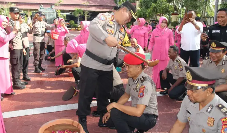 Kapolresta Palu Kombes Pol Deny Abrahams menyiramkan air kembang kepada personel yang naik pangkat di Mapolresta Palu, Rabu (31/12/2025). (©Humas Polresta Palu)