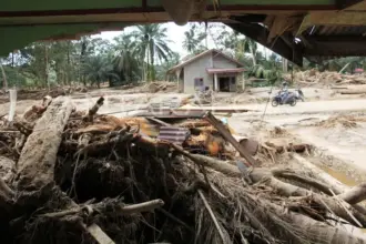 Warga melintas di area rumah yang terdampak banjir bandang di Desa Aek Garoga, Kecamatan Batang Toru, Tapanuli Selatan, Sumatera Utara, Senin (1/12/2025). Berdasarkan data dari BPBD Tapanuli Selatan Senin (1/12) diwilayahnya sebanyak 50 orang meninggal dunia dan 46 orang belum ditemukan akibat bencana banjir bandang dan longsor pada Selasa (25/11).ANTARA FOTO/Yudi Manar/YU