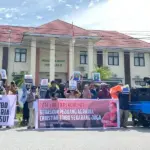Aksi solidaritas menuntut pembebasa Christian Toibo di depan PN Poso, Kamis (18/12/2025). (©Pengacara Hijau Indonesia)
