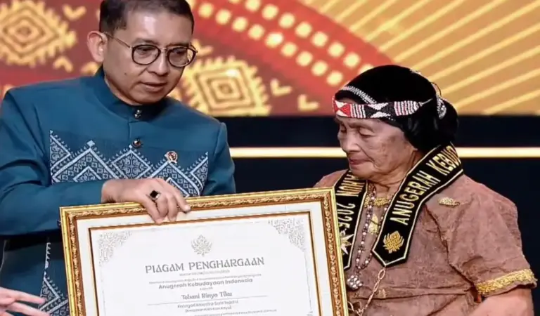 Menteri Kevudayaa Fadli Zon menyerahkan piagam penghargaan kepada maestro seni asal Sulteng Ina Tobai atas dedikasinya menjaga dan melestrikan trasdisi pembuatan kain kulit kayu di Jakarta, rabu (17/12/2025). (©Tangkapan layar Kemenbud)