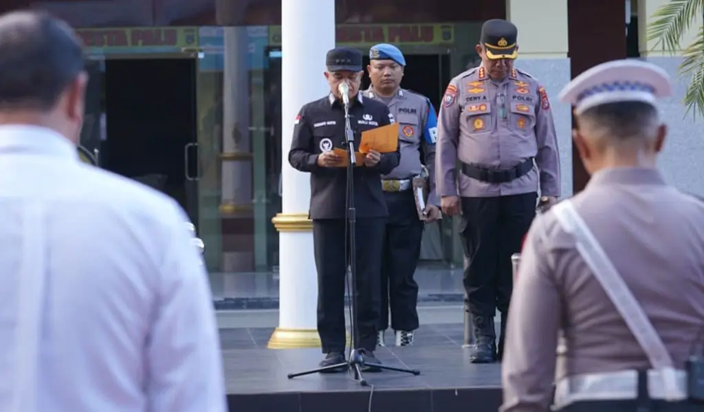 Wali Kota Palu, Hadianto Rasyid (tengah) membacakan sambutan Kapolri saat memimpin apel gelar pasukan Operasi Lilin Tinombala 2025 menjelang Natal dan Tahun baru di mapolresta Palu, Jumat (19/12/2025). (©Prokopim Setda Kota Palu/Iwan)