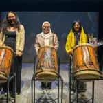 Sekretaris Daerah Kota Palu Irmayanti (tengah) bersama Direktur Festival Tetaer Indonesia Pradetyo Novitri (kiri) dan Sutradara Lentera Silolangi Annisa Saskia Putri (kanan) memukul gimba menandai pembukaan Festival teater Indonesia di Palu, Sulawesi Tengah, Sabtu (6/12/2025). (©bmzIMAGES/Basri Marzuki)