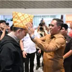 Gubernur Sulteng Anwar Hafid memasangkan siga ke Menbud Fadli Zon saat tiba di Bandara Mutiara Sis Aljufri Palu, Senin (29/12/2025). (©Biro Adpim Sulteng)