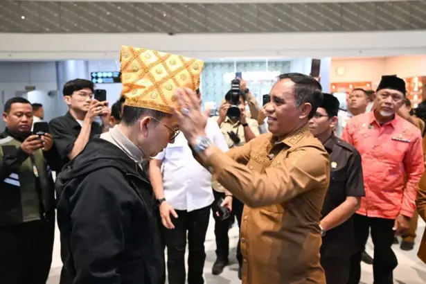 Gubernur Sulteng Anwar Hafid memasangkan siga ke Menbud Fadli Zon saat tiba di Bandara Mutiara Sis Aljufri Palu, Senin (29/12/2025). (©Biro Adpim Sulteng)