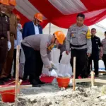 Kapolres Sigi AKBP Kari Amsah Ritonga meletakkan batu pertama pembangunan gedung SPPG di Desa Maku, Sigi, Senin (29/12/2025). (©Humas Polres Sigi)