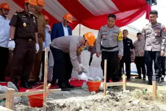 Kapolres Sigi AKBP Kari Amsah Ritonga meletakkan batu pertama pembangunan gedung SPPG di Desa Maku, Sigi, Senin (29/12/2025). (©Humas Polres Sigi)