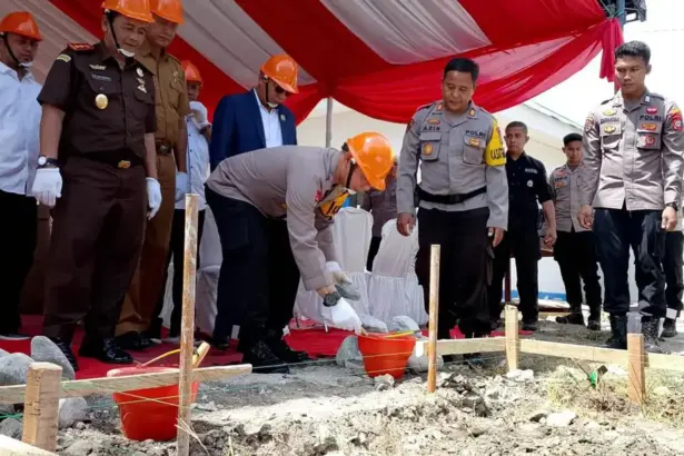 Kapolres Sigi AKBP Kari Amsah Ritonga meletakkan batu pertama pembangunan gedung SPPG di Desa Maku, Sigi, Senin (29/12/2025). (©Humas Polres Sigi)