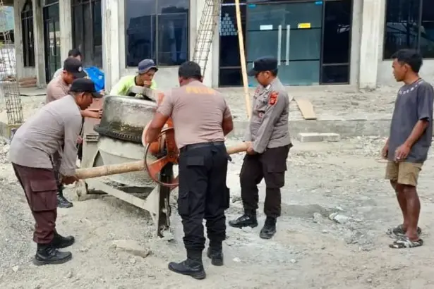 Sejumlah personel Polsek Lore Utara membuat adonan semen pada Bakti Religi pembangunan masjid di desa tersebut, Jumat (19/12/2025). (©Polsek Lore Utara)