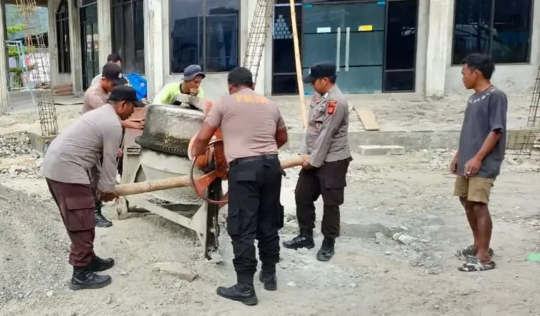 Sejumlah personel Polsek Lore Utara membuat adonan semen pada Bakti Religi pembangunan masjid di desa tersebut, Jumat (19/12/2025). (©Polsek Lore Utara)