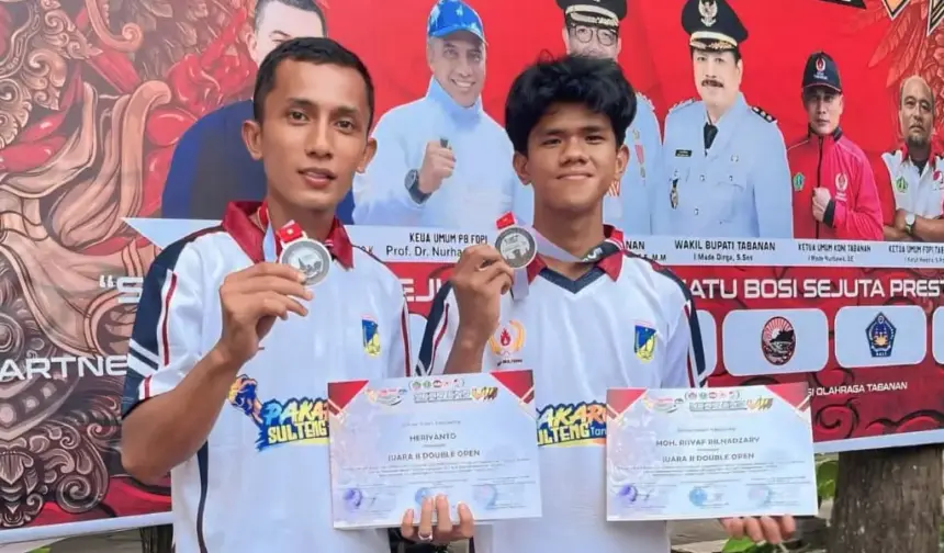 Pratu Heriyanto (kiri) menunjukkan medalinya usai memenangkan pertandingan pada Open Petanque Competition 2025 di Tabanan, Bali, Selasa (30/12/2025). (©Pendam23)