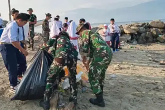 Warga bersama TNI AD bergotong royong membersihkan sampah di Pantai Uesalura, Tondo, Palu, Selasa (28/1/2026). (©Kodim 1306/KP)