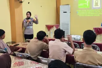 Personel Polantas Polresta Palu menyampaikan materi lalu lintas di SMAN 4 Palu, Rabu (14/1/2026). (©Humas Polresta Palu)